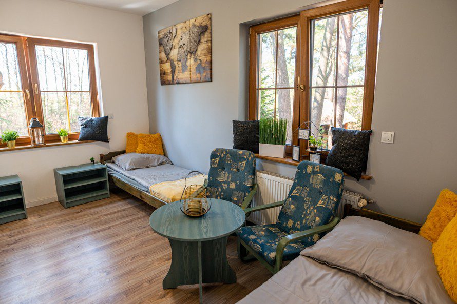 Pokój dwuosobowy z wygodnymi fotelami i stolikiem – Hostel Zone Słupsk